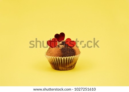 Muffin with hearts stock images. Chocolate muffin with heart on a yellow background. Sweet birthday pastry. Valentines Day concept