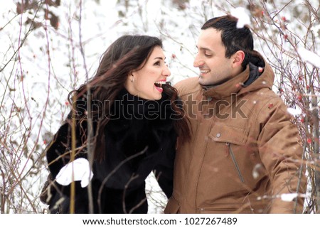 A young couple walk in a winter park outdoor