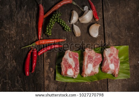 raw pork meat ribs with ingredients for cooking, dark background, top view