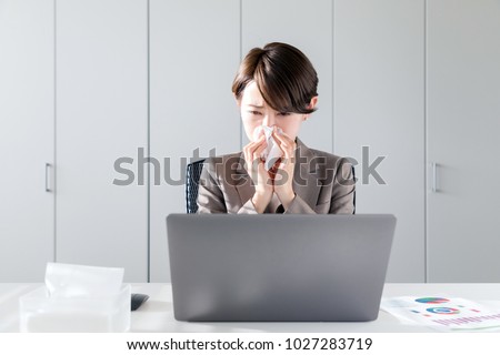Young asian woman blowing her nose. Nasal inflammation. Hay fever. Royalty-Free Stock Photo #1027283719
