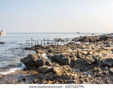 Rocks on the beach, rocks in the sea, and waves.