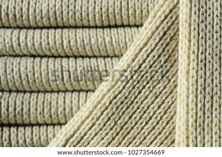 Composition of a soft yellow knitted sweater. Macro texture of bindings in yarns