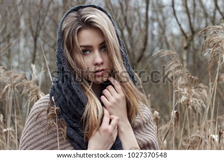 beautiful sad girl is walking in the field. Photo in brown tones.