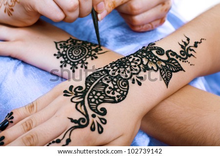 Image detail of henna being applied to hand Royalty-Free Stock Photo #102739142