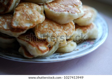 Thick russian pancakes piled on neutral background.