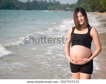 Happy beautiful pregnant woman on the sea in the bikini on hte nature 