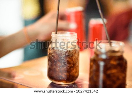 soft drink Put ice in a glass place it on a wooden table.