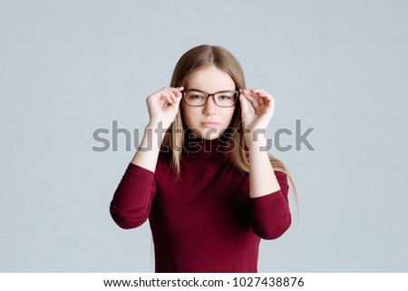 emotion. The young attractive blonde in stylish glasses looking at camera with serious or pensive expression.portrait in studio on a white background. Short-sightedness or far-sightedness.