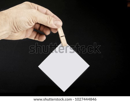 Paper note on the finger fixed with clothes pin