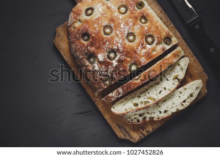 ciabatta Italian bread with olives on a wooden surface