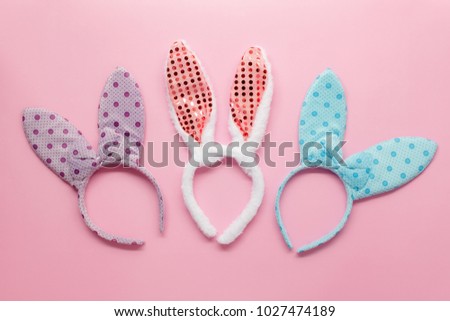 Top view aerial image of decoration fashion on Happy Easter holiday background concept.Flat lay accessory costume bunny ear on modern beautiful pink paper at home office desk.pastel tone design.