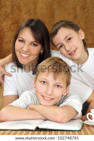 Joy charming mom and sons sitting on a brown background