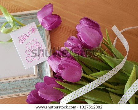 It's a girl tag with a tulip bouquet and vintage picture frame