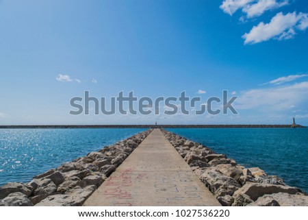A path that leads to the beacon located at the Bar Marina, Montenegro, Adriatic Sea.  Royalty-Free Stock Photo #1027536220