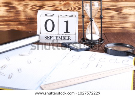 Handwritten alphabet in notebook with office stationery on brown wooden table