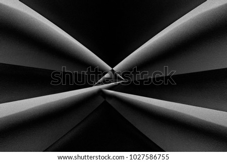 Angular girders with glass prism placed in the center of frame for refraction / distortion effect. Abstract architecture in darkness. Strong contrast black and white photo with chiaroscuro composition