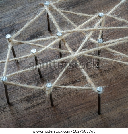 a symbol picture for networking. nails are connected by jute twine.