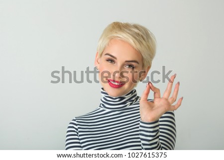 happy beautiful young girl with a smile on her face with a short hairstyle on a light background