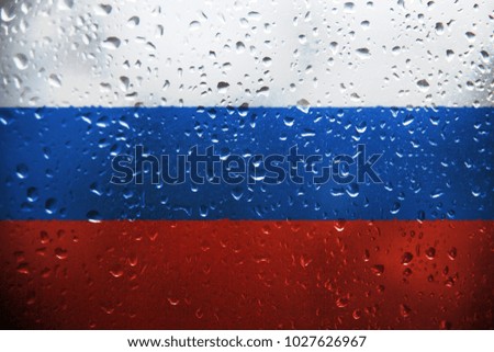 Texture of the Russian flag on the glass with drops of rain.
