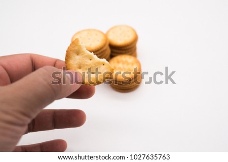 Hand holding a biscuit on blur white background.