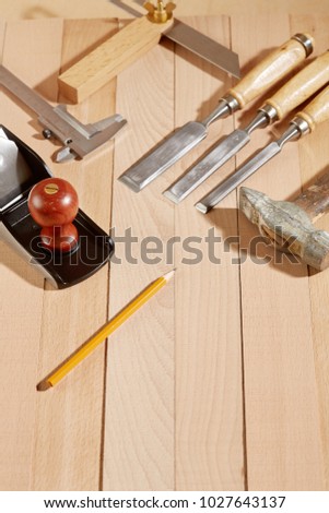 DIY concept. Woodworking and crafts tools. Carpentry hand tools on a workbench. Planers, chisels, measuring tools.  Wooden parts, planks and stocks. Wooden background. Top view.