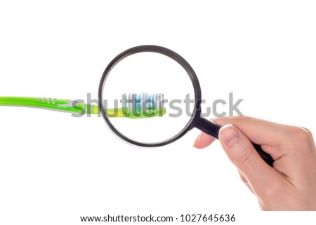 Reading glass zoom germs dirty mold damp wet oral body bodycare pampering lens concept. Close up photo of person's hand holding magnifier demonstrating microbes toothbrush isolated on white background