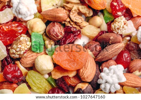 Tasty sweet mix dried fruits colorful background. A set of textures of nuts, legumes and dried fruits. 