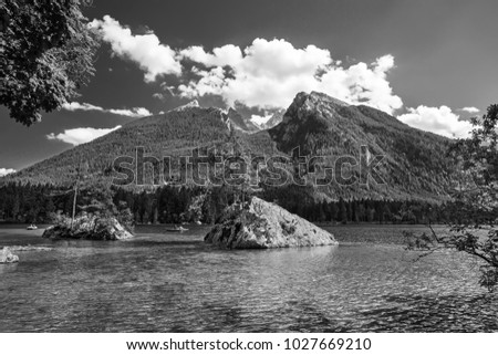 Beautiful scene of trees on a rock island in idyllic scenery at  lake Hintersee with blue sky and clouds in summer, National park Berchtesgadener Land, Upper Bavaria, Germany
