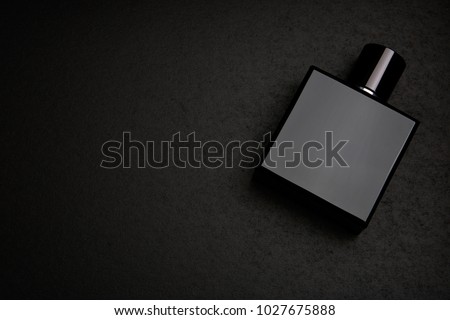 Mockup of black fragrance perfume bottle mockup on dark empty background. Top view. Horizontal Royalty-Free Stock Photo #1027675888