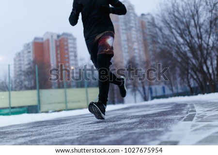 Picture of athlete running at stadium in winter