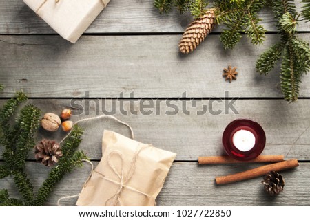 Top view of christmas tree branches , gift boxes and nuts on old wooden background. Christmas decorations, copy space for text.