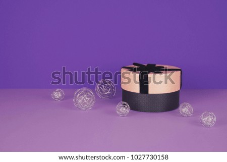 Pink gift box with ribbon on an ultraviolet background with copy space.