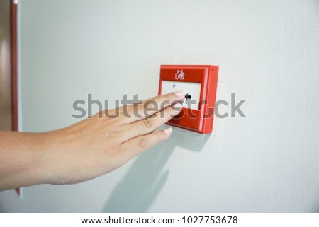 Hand of woman pulling fire alarm switch