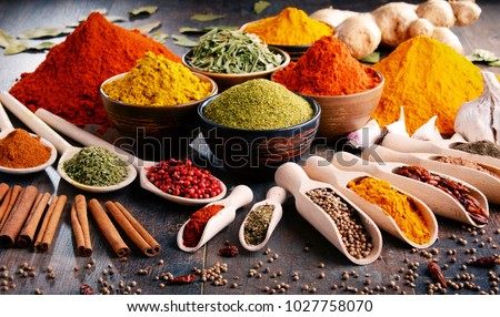 Variety of spices and herbs on kitchen table. Royalty-Free Stock Photo #1027758070