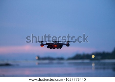 Drone flying at sunset over pink sky in Maldives