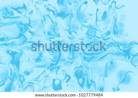 Blue wet abstract paint leaks and splashes texture on white watercolor paper background. Natural organic shapes and design.