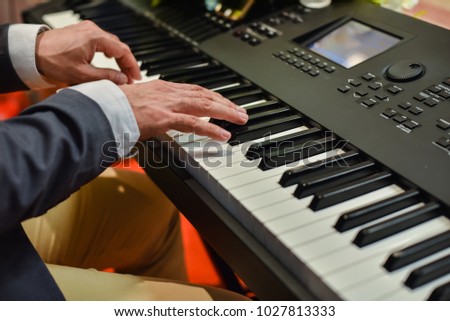 The hands of a musician are playing the piano. 