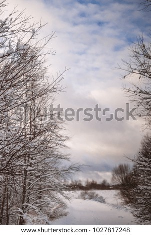 Photo of snowy landscape with cloudy sky on winter day