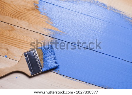 Brush in blue paint on the boards. Paint