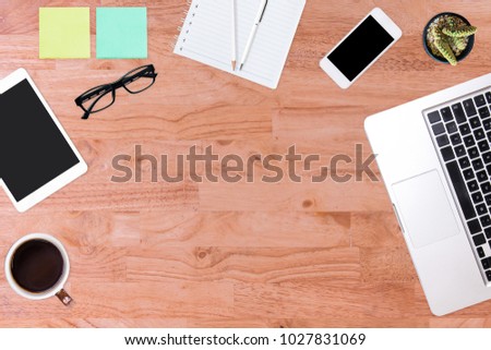 Modern office desk wooden table with laptop computer, smartphone, notebook, pen, pencil, and cup of coffee. Working desk table concept.Top view with copy space, flat lay.