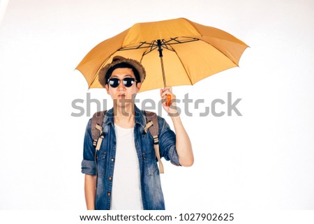 Young Asian tourist holding umbrella isolated over white background. Alone and Looking for partner to travel