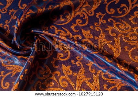 Texture, background, pattern. silk cloth Royal monogram. Moses Velvet with a design of gold foil lilies. Soft, light velvet depicts a playfully twirled design in decadent gold.
