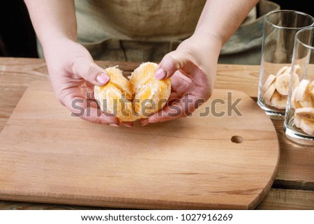 A woman breaks an orange by her own hands