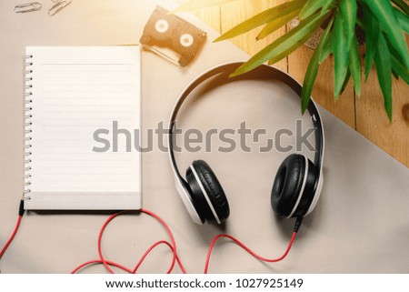 empty notebook with headphones on table ,top view