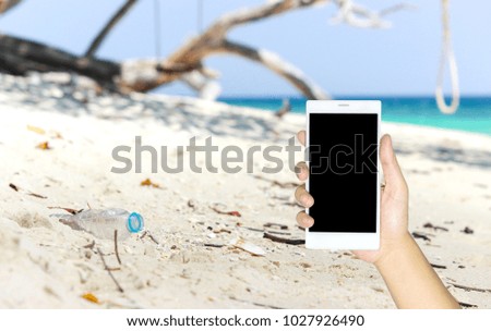 Man use mobile phone, a plastic bottle was dumped at the beach.