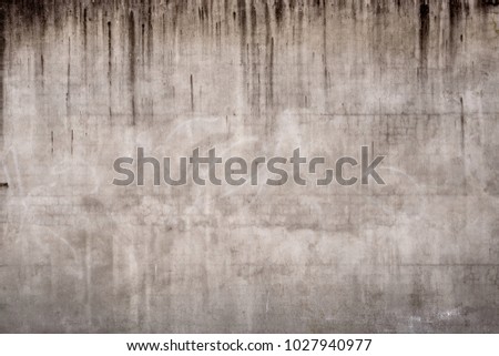 Abstract background texture of rendered concrete wall with small cracks and watermarks.