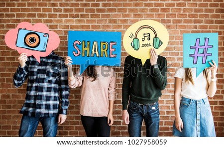 Friends holding up thought bubbles with social media concept icons Royalty-Free Stock Photo #1027958059