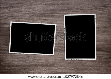 two blackened old vintage photo templates on rustic wooden background