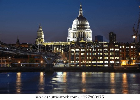 The dome of St. Paul's Cathedral is illuminated at night on the Thames River in London, England.