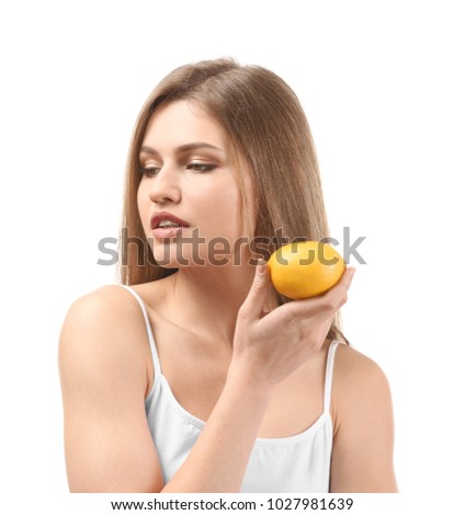 Beautiful young woman with ripe lemon on white background
